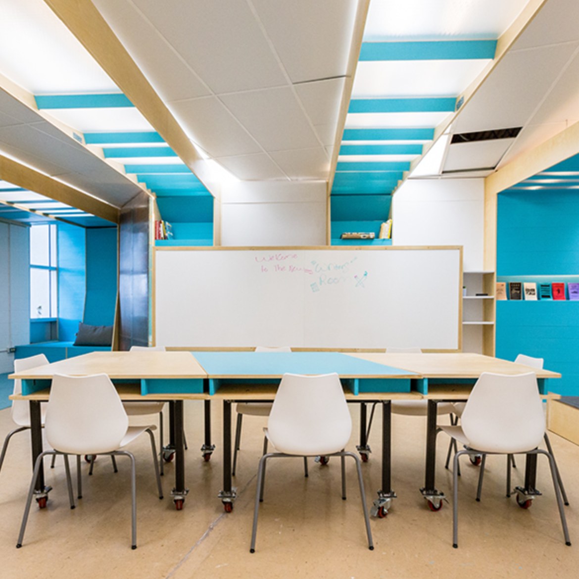 Image of a class room with a white board and white chairs