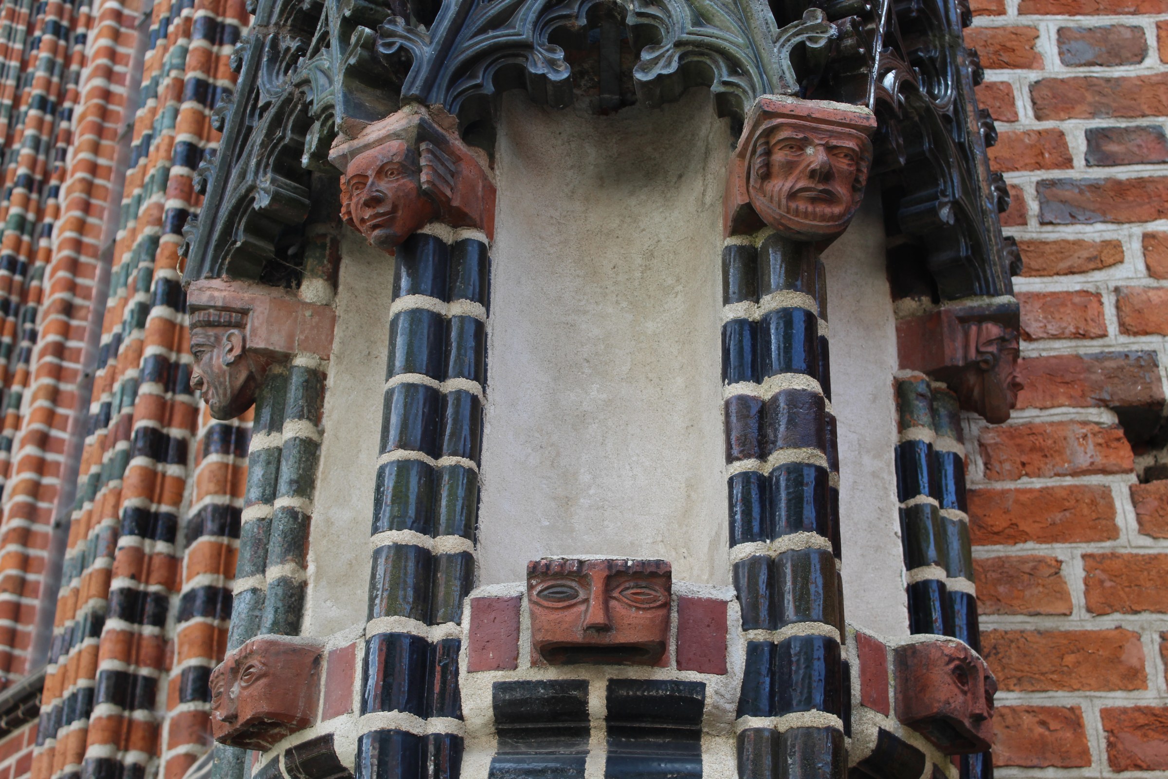 A zoomed in image of the side of a building, brick gothic architecture