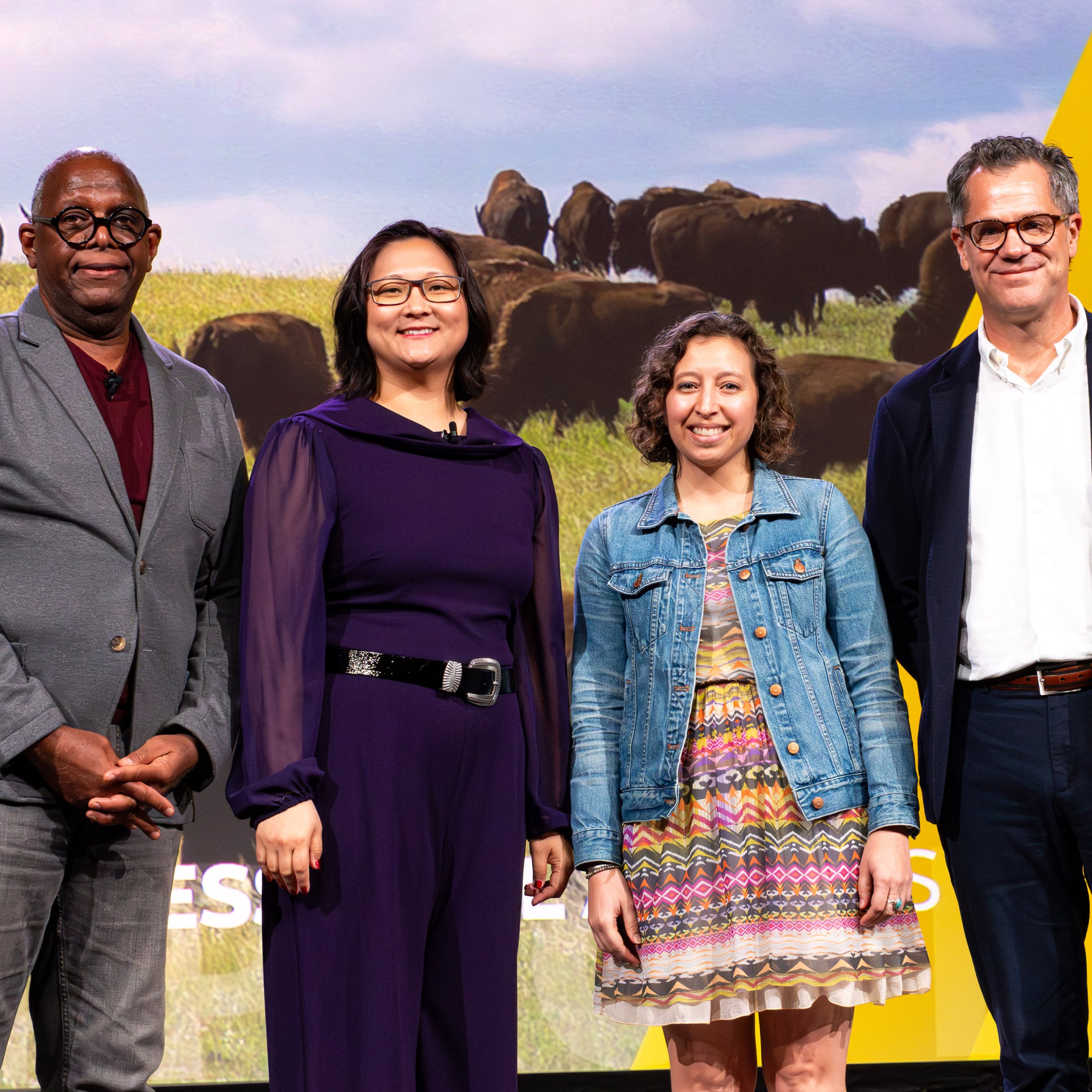 Four people standing in front of a screen.