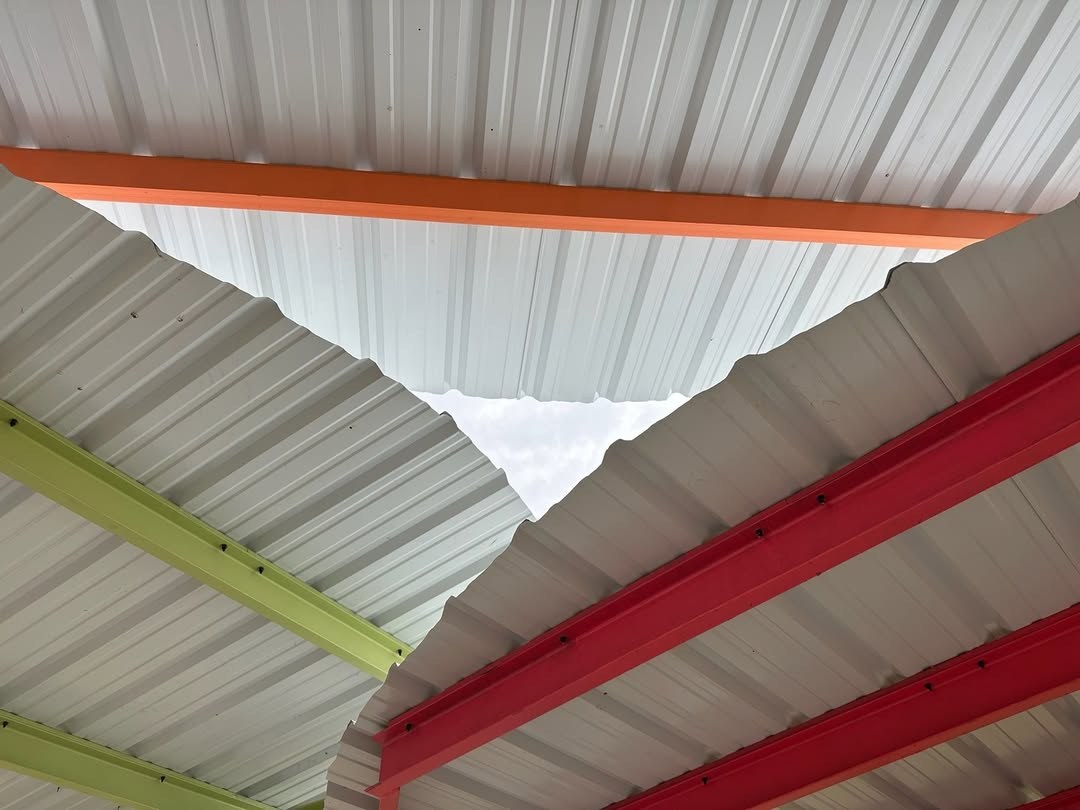 Close up view from underneath the corrugated metal roof, made of three, overlaping circular shaped pieces, of Sprout House on the Lafitte Greenway