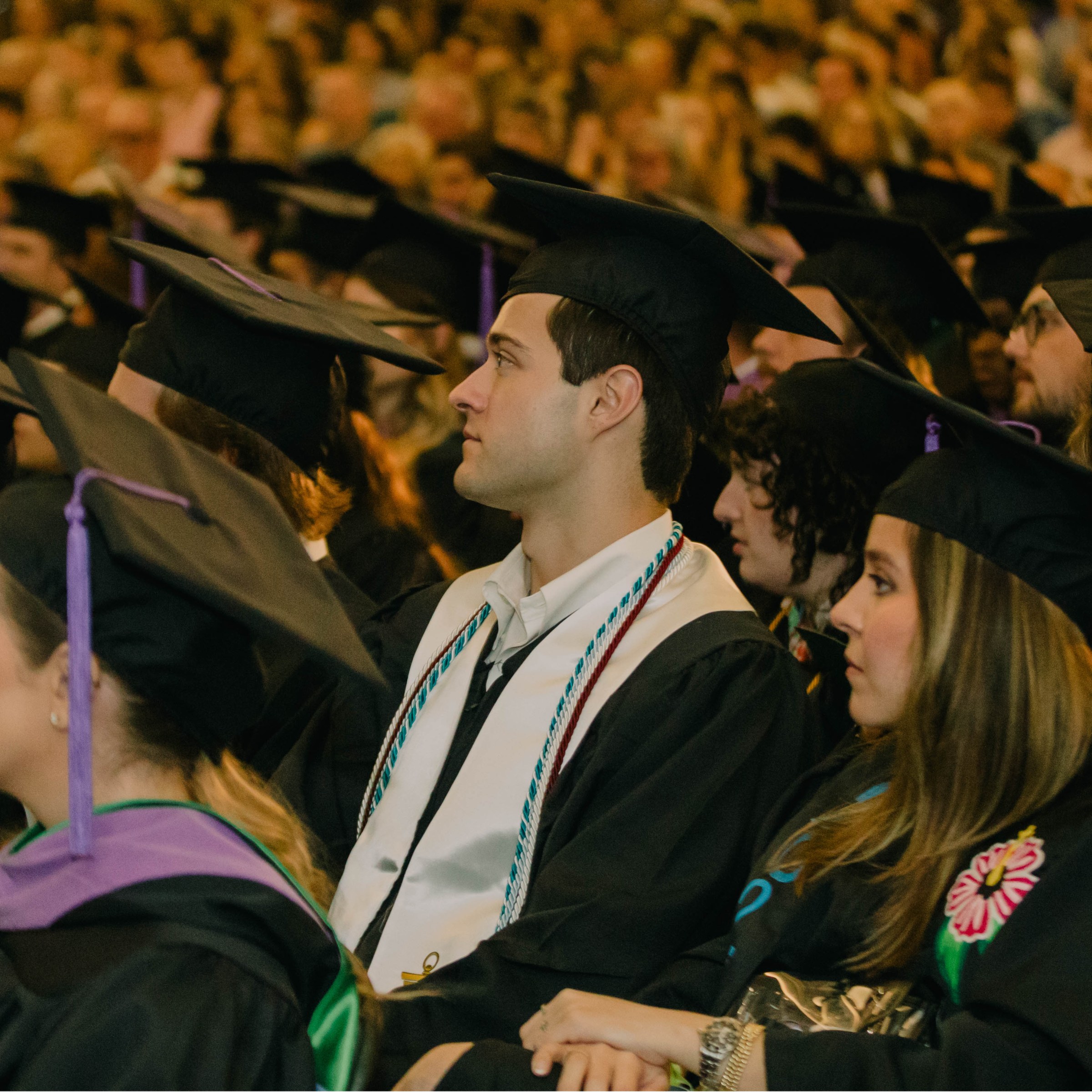 picture of students sitting at commencement with graduation caps