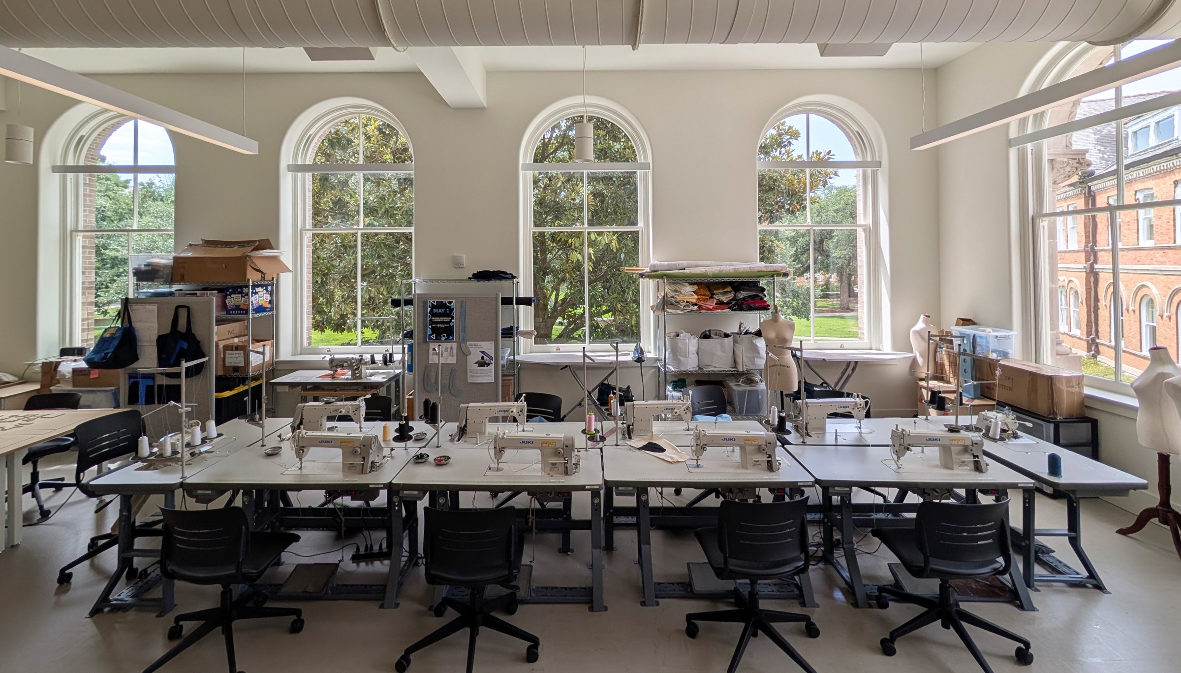 one point perspective of the textile lab in RMH. view of sewing machines with arched windows as the backdrop.