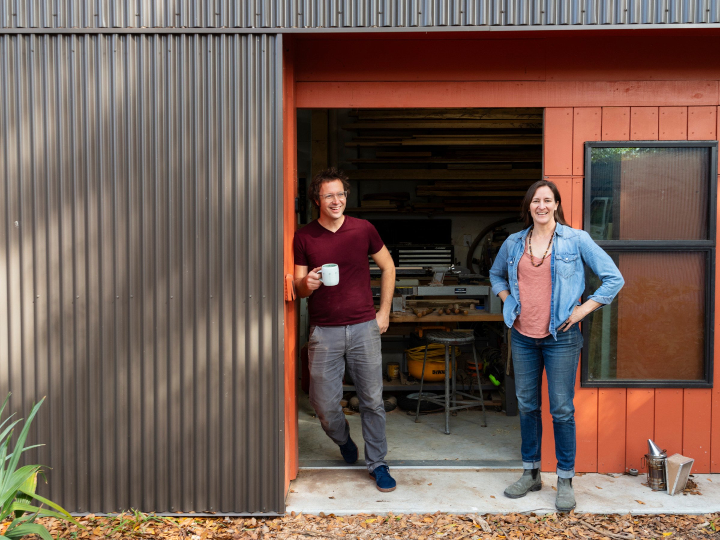 Environmental portrait of Colectivo's Seth Welty and Emilie Taylor Welty, both alumni, standing outside their home woodshop.