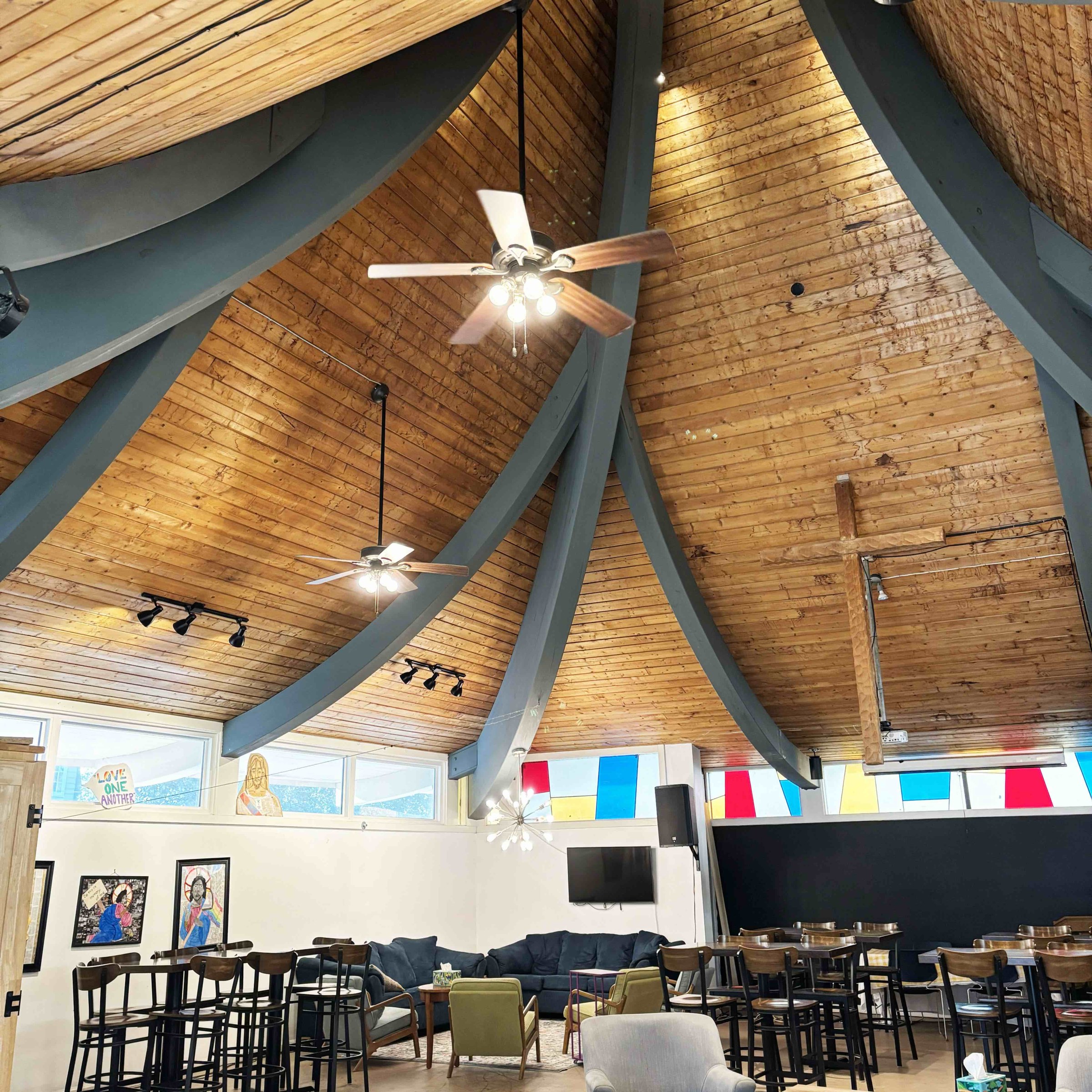 The interior of a site of worship with wooden ceiling and rafters