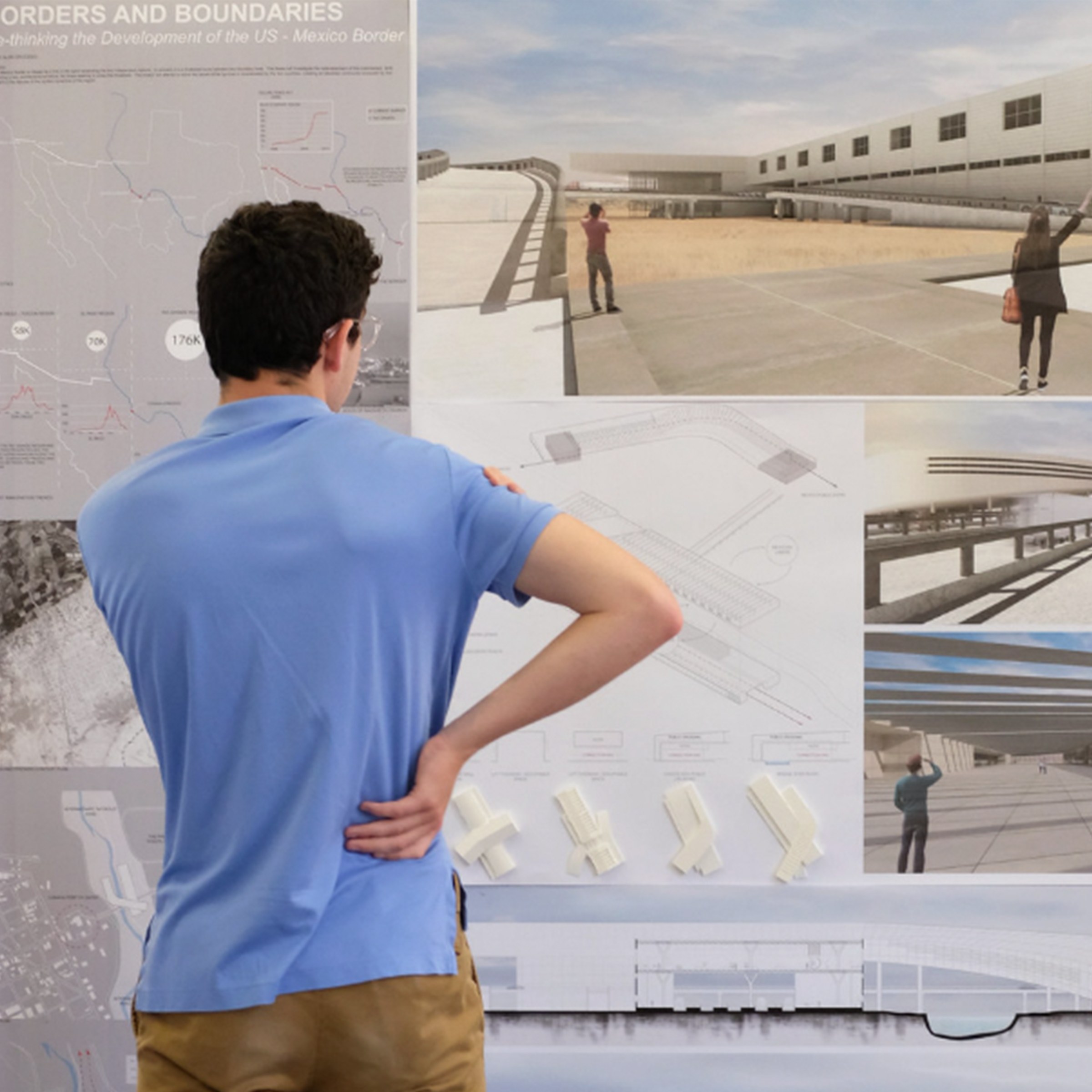 Man in blue shirt looking at images on the wall