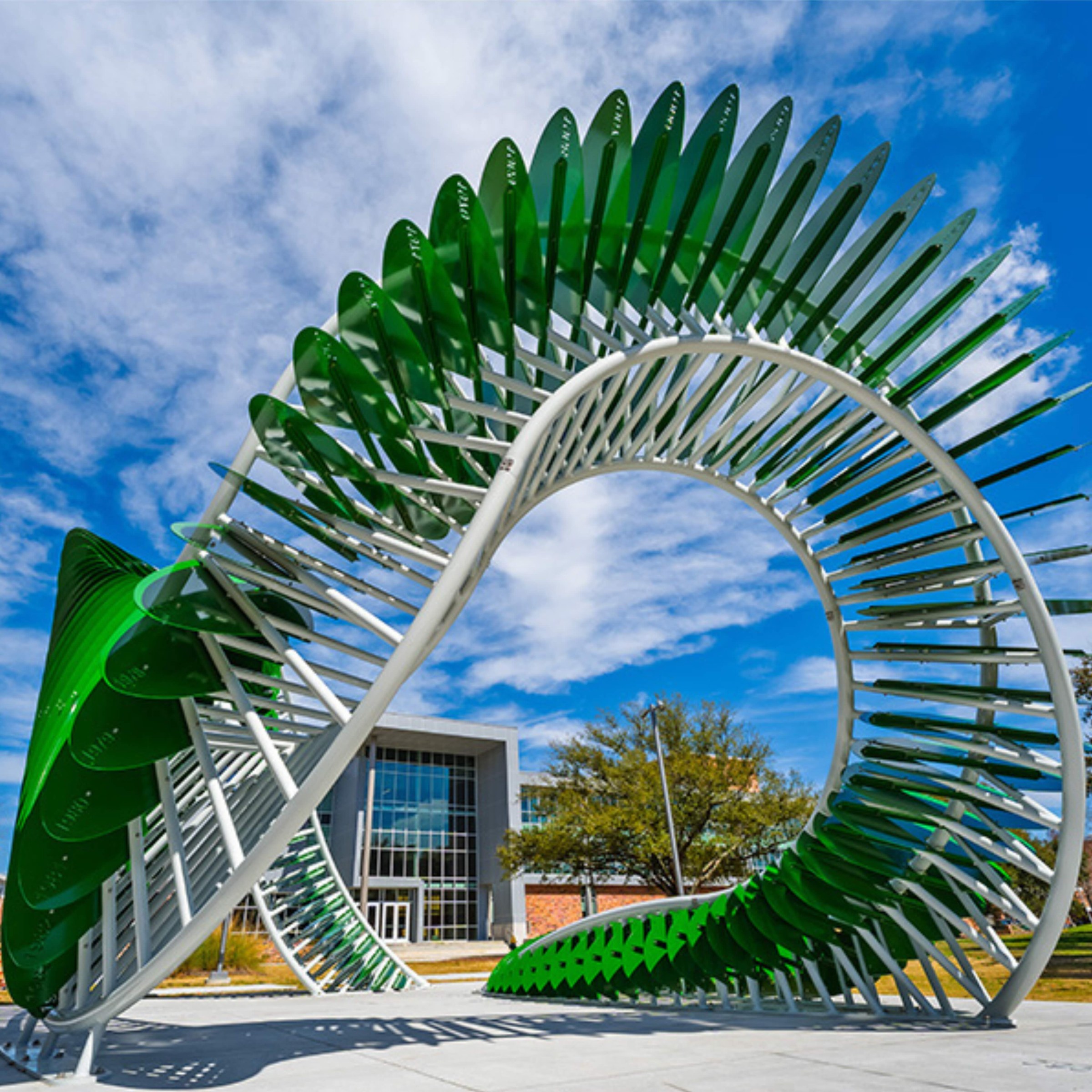 AION sculpture in front of large gray building on university campus