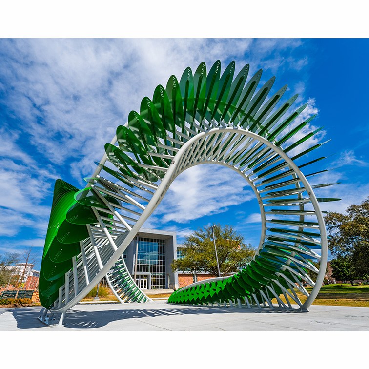 AION sculpture in front of large gray building on university campus